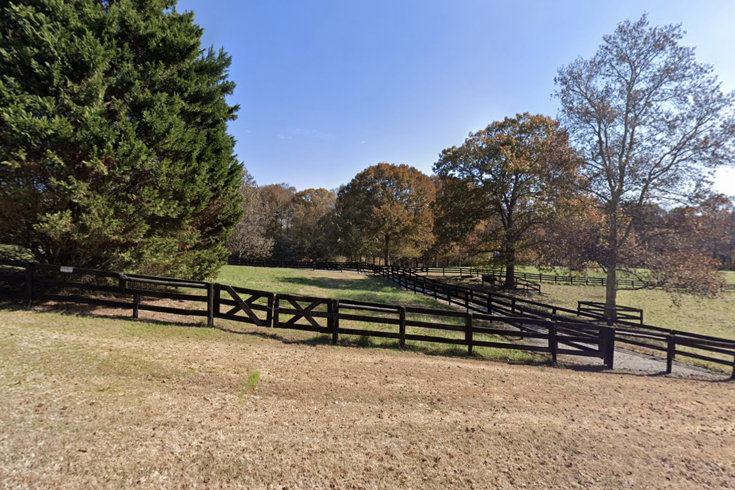 CBH International entrance, with pastures, farm fencing and large trees