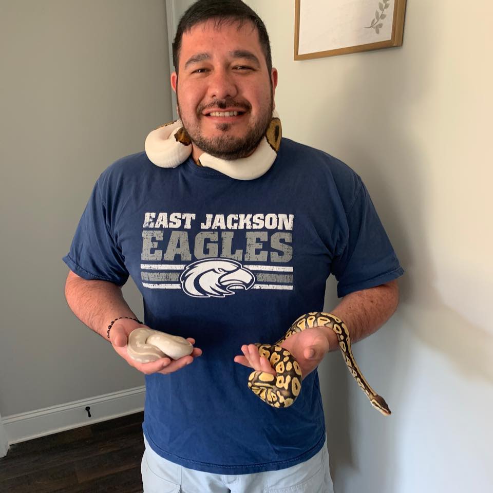 Pedraza smiles while handling three snakes