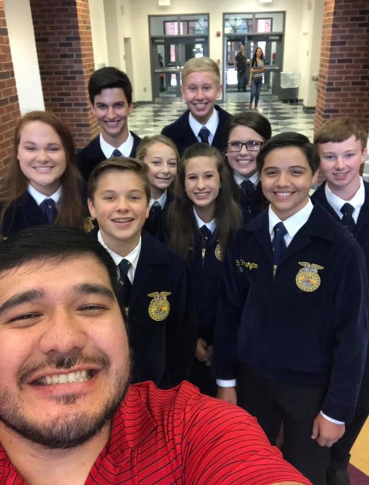 Pedraza poses with his students, who are all in the FFA uniform, while representing Madison County High School FFA.