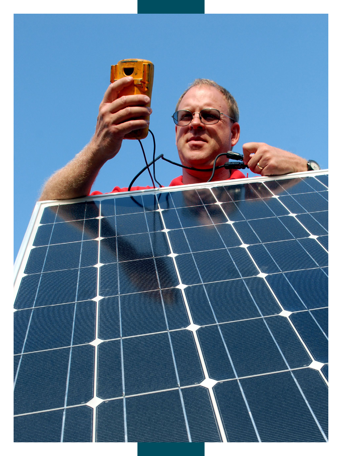 Hawkins stands above a solar panel hooked up to a digital monitoring system, which he is assessing