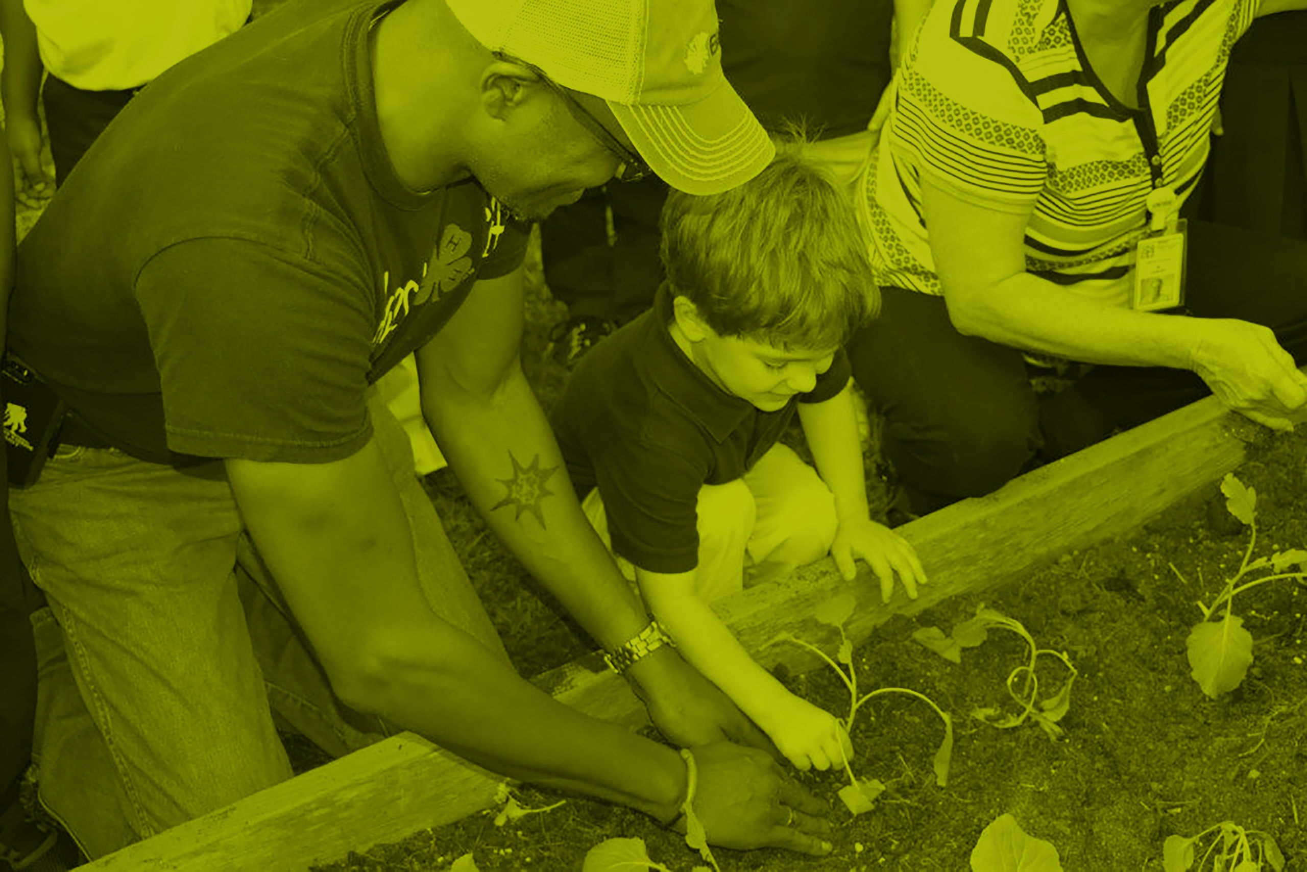 Overhead shot of agent planting in a flowerbed with a young child.