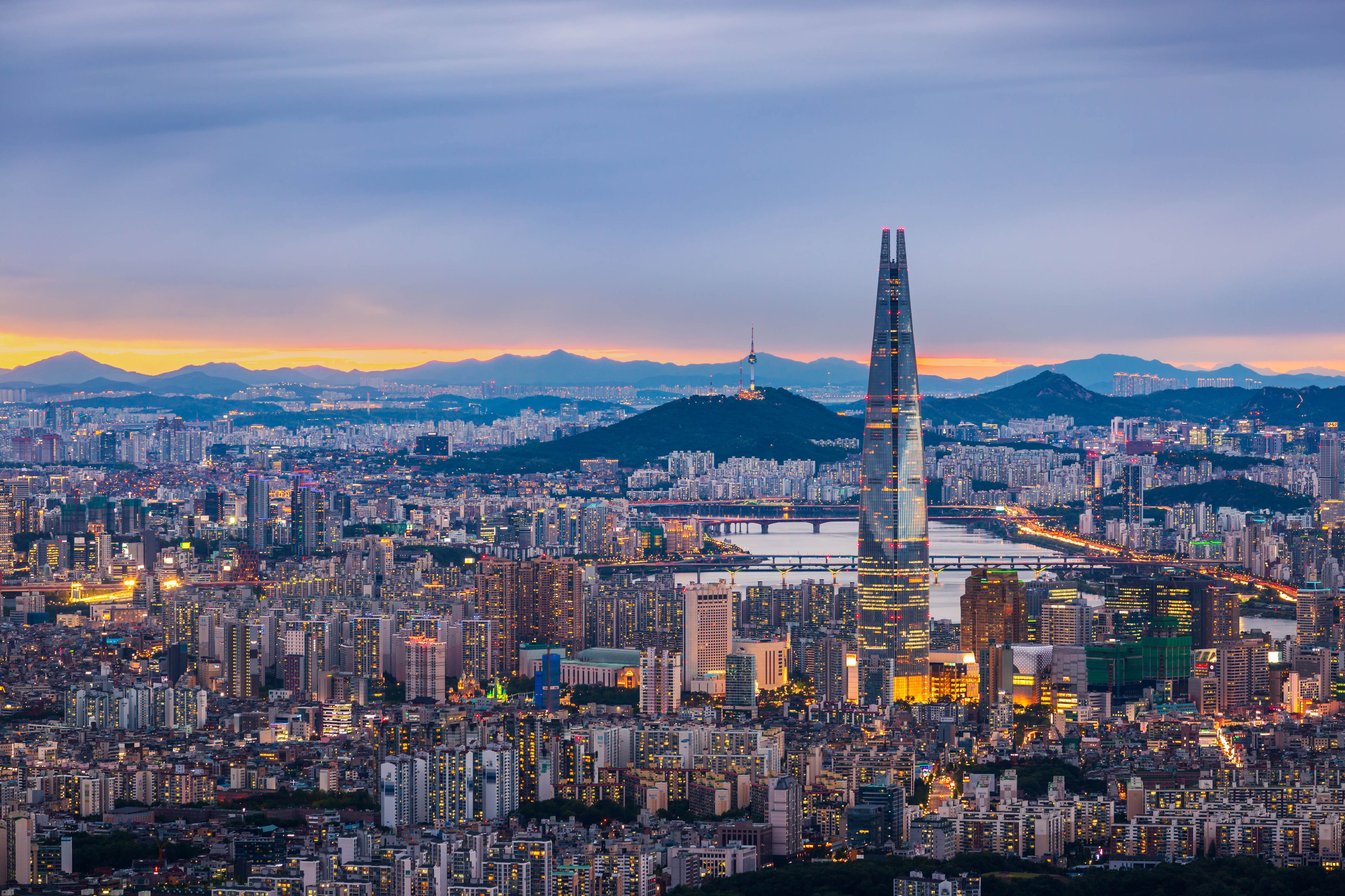 Seoul City skyline and downtown with a view of Namhansanseong mountain at sunset.