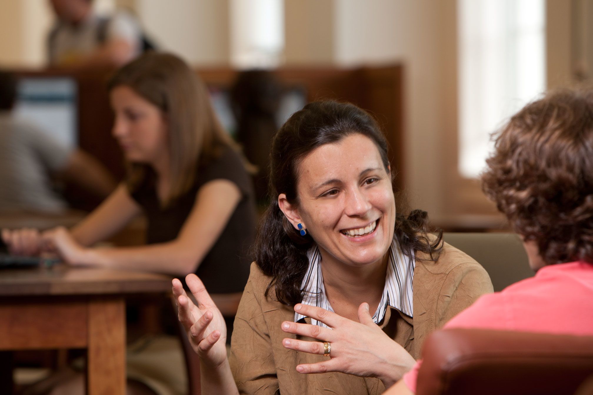 Professor Maria Navarro gestures while explaining a concept in a classroom setting