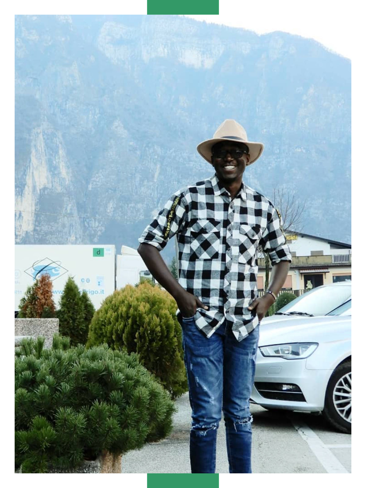 Kelvin Jimmy Awori stands on a sidewalk next to a railing in an autumnal scene, with orange and yellow leaves all around him