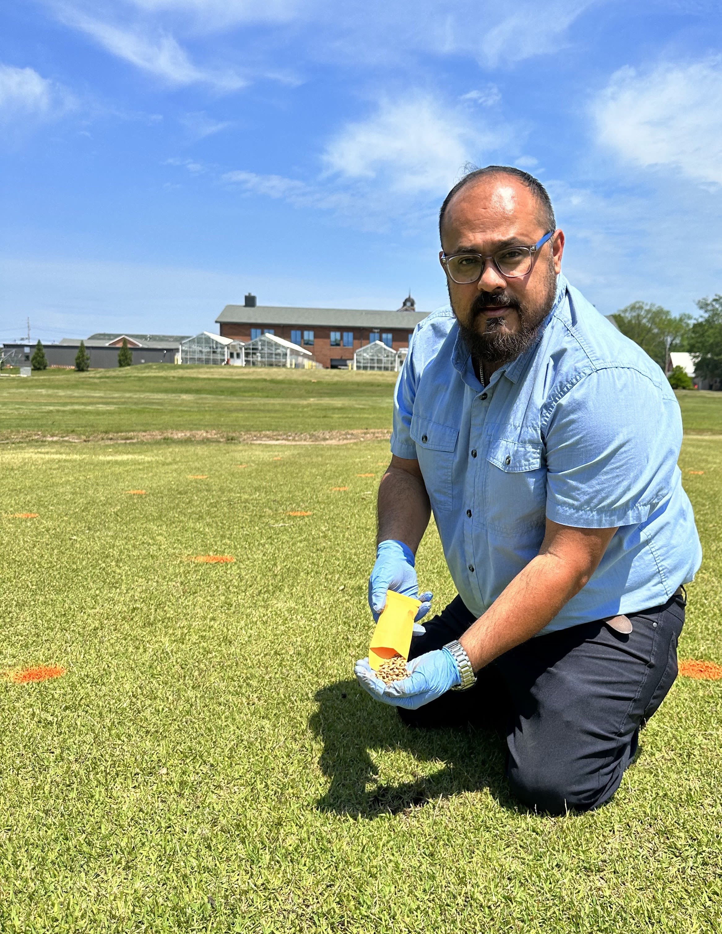 Orellana kneels down at the irrigation demonstration site at UGA-Griffin