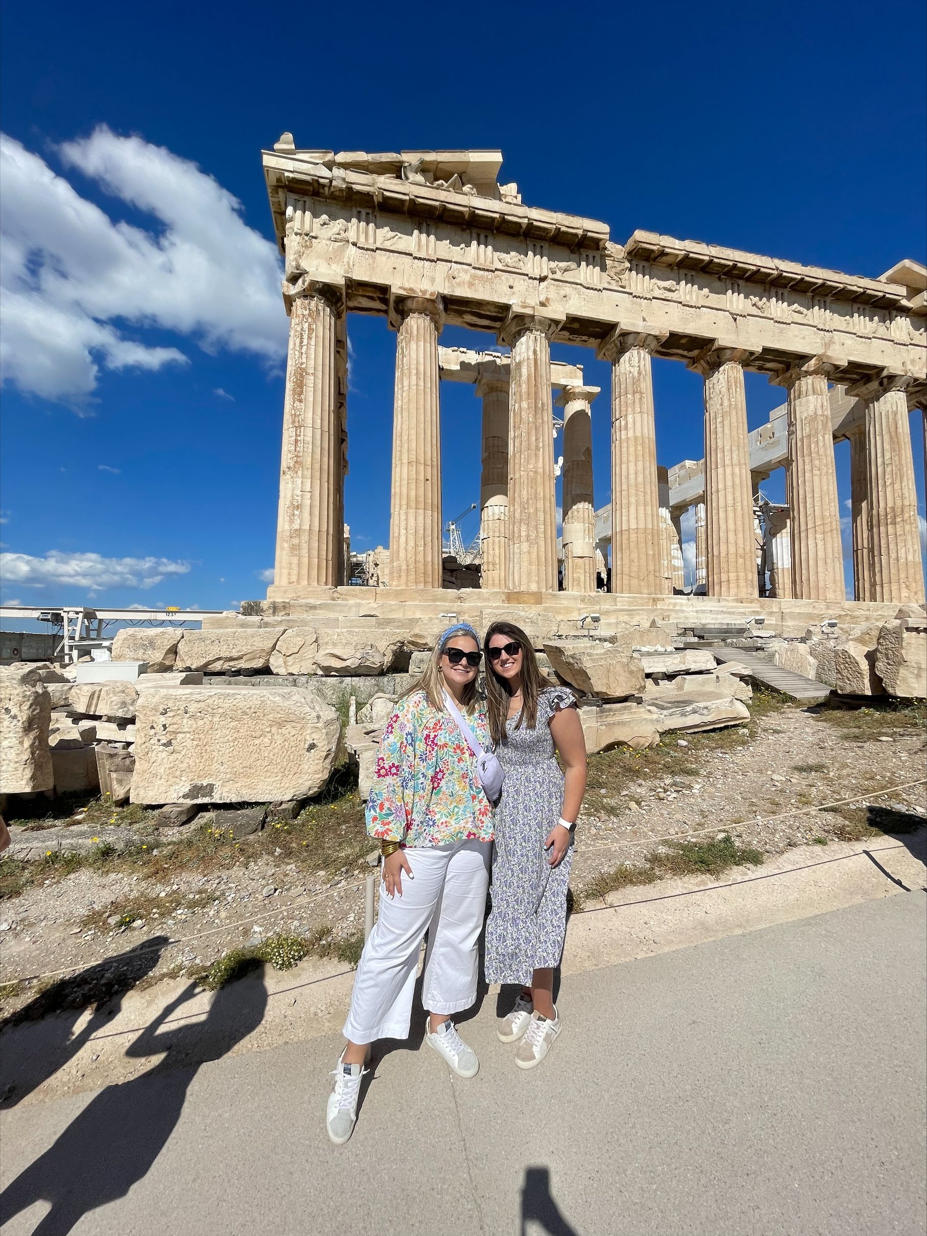 Sara Beth Massey and Olivia Phillips stand in front of ruins in Greece.