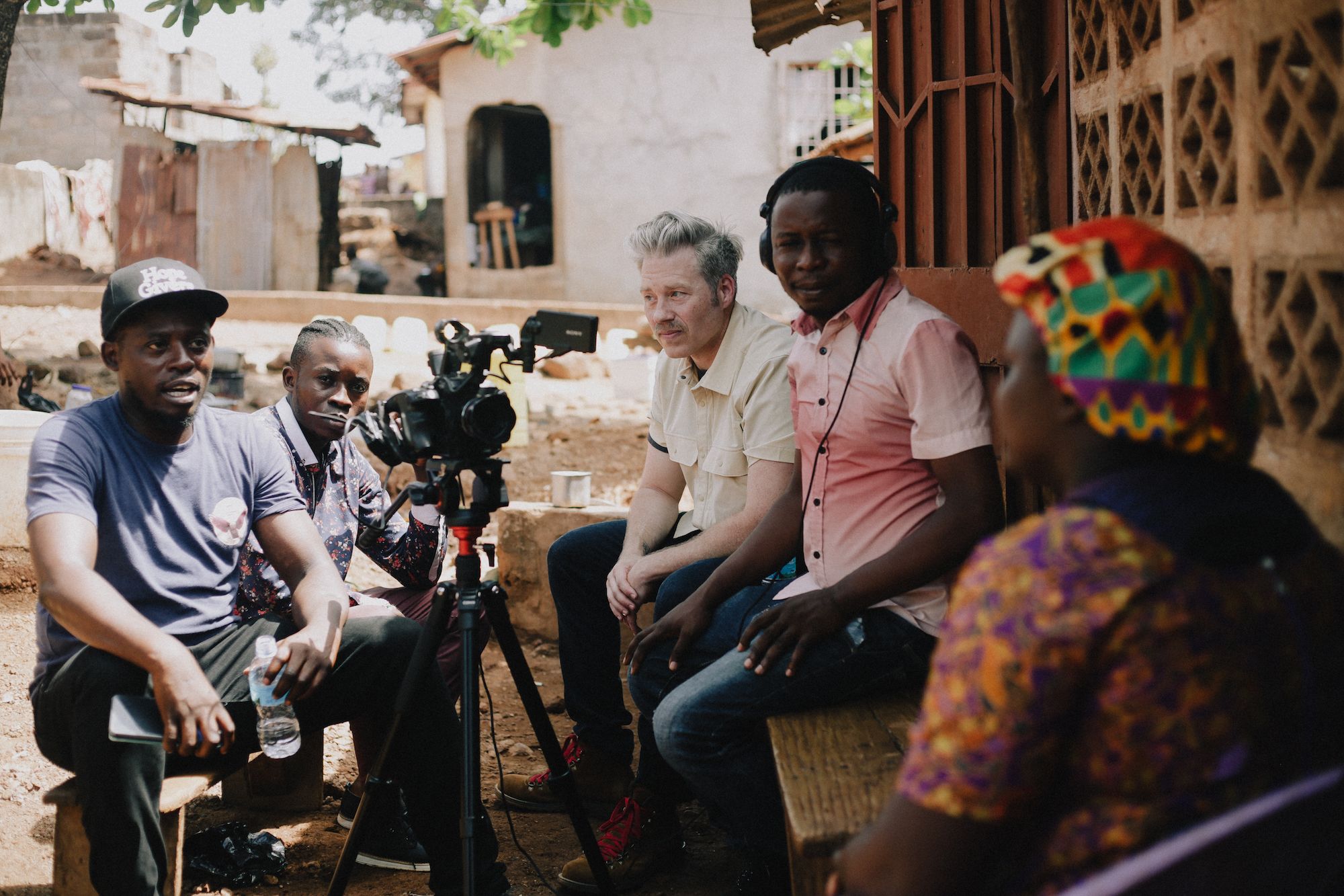 Tamlin Hall and his crew filming a documentary scene outdoors in Sierra Leone