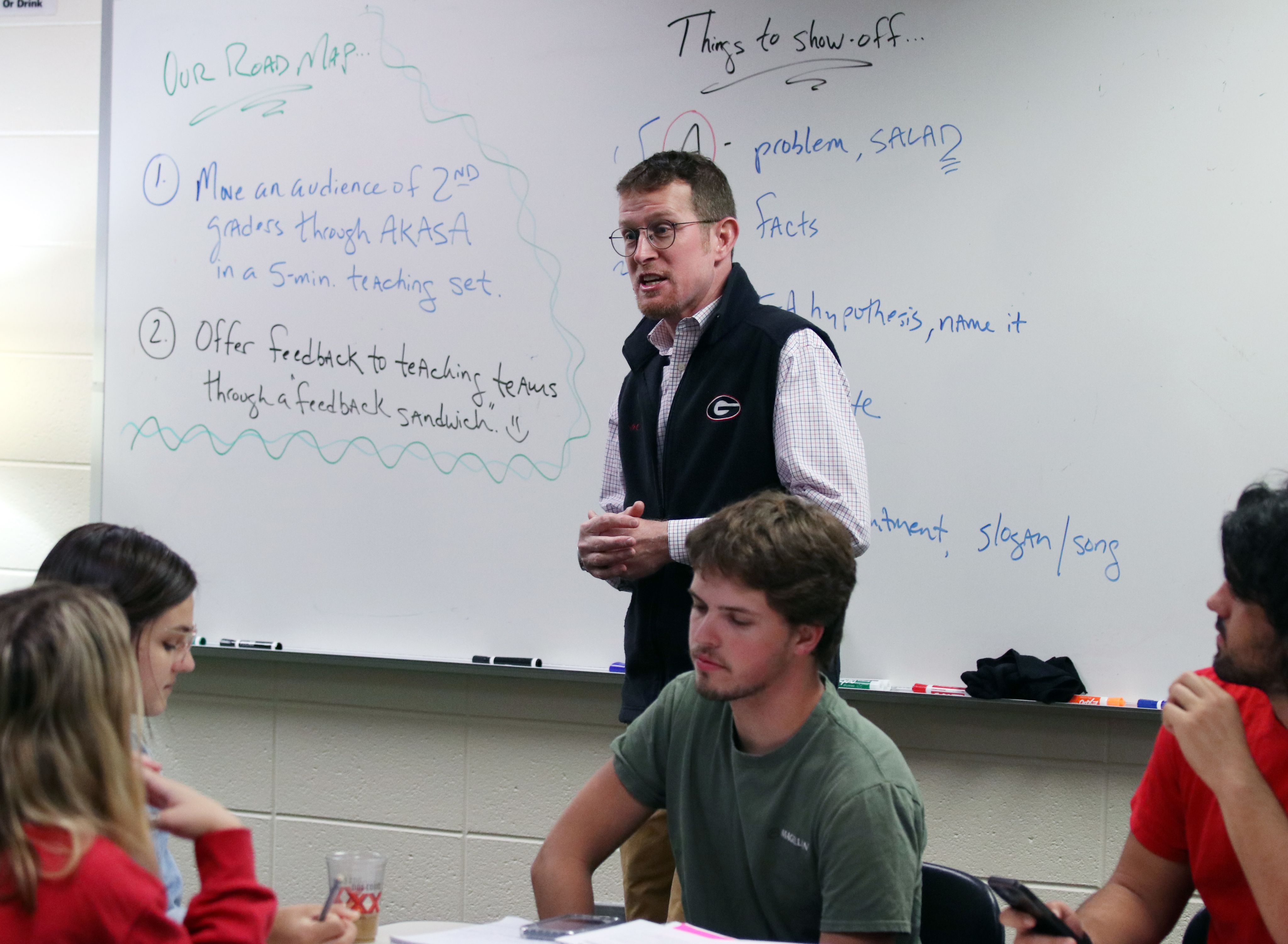 Fuhrman speaks at the front of the class using a whiteboard